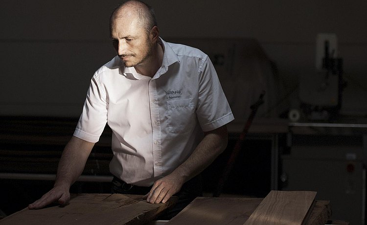 De fineermeester laat zijn hand bijna liefkozend over het hout gaan.