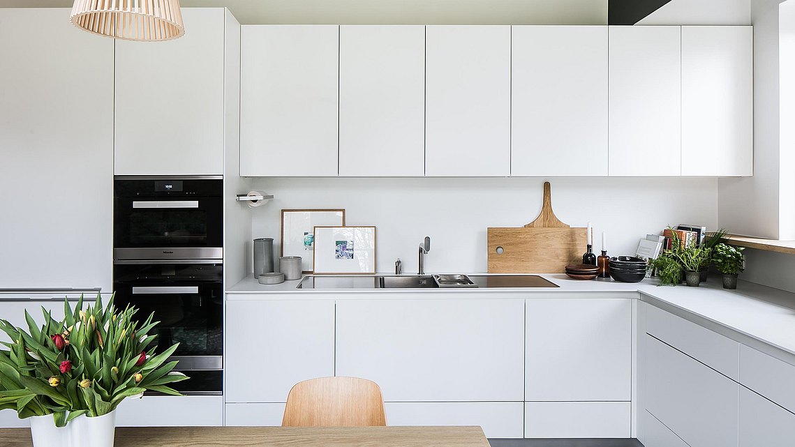 De witte b3-keuken is minimalistisch, maar vormt een mooi contrast met de originele tegel van het huis. 