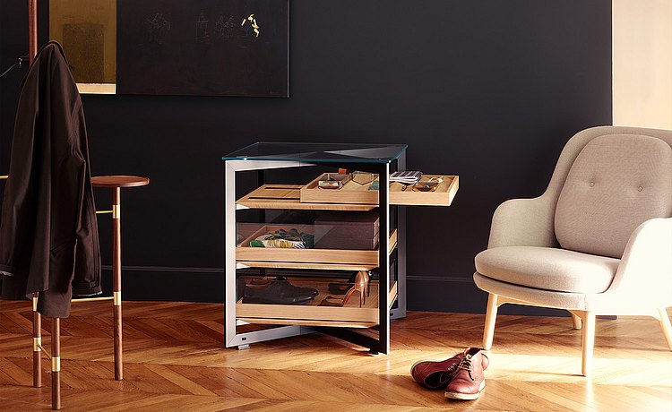 b Solitaire glass, 70 cm-long, with three pull-out wood trays as a storage place for personal items