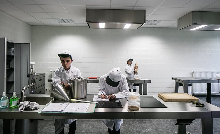 Leerlingen aan het werk aan de bulthaup werkbanken.