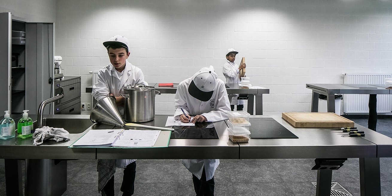 Leerlingen aan het werk aan de bulthaup werkbanken.