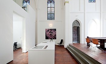 De vrijstaande keuken staat centraal in de verbouwde kerk.